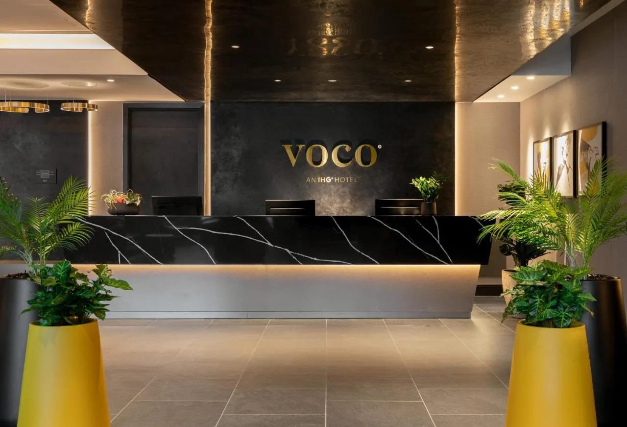 Lobby with a reception counter and potted plants at voco Edinburgh - Haymarket by IHG